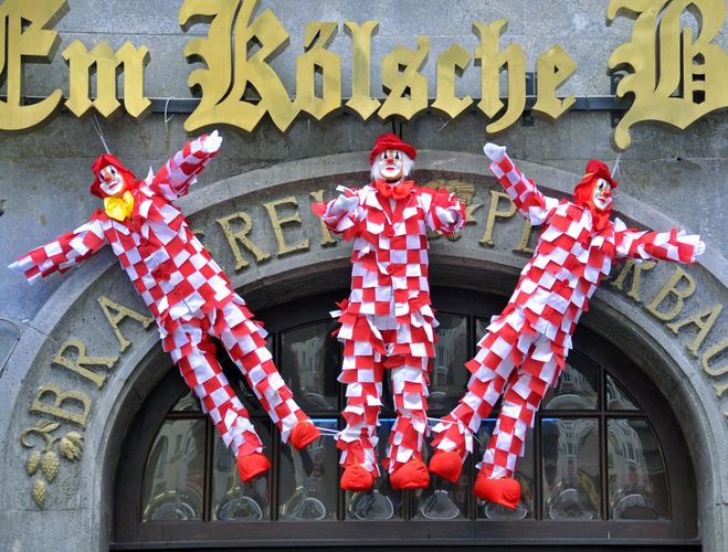 Three Nubbel figures hanging over Em Kölsche Eck doorway